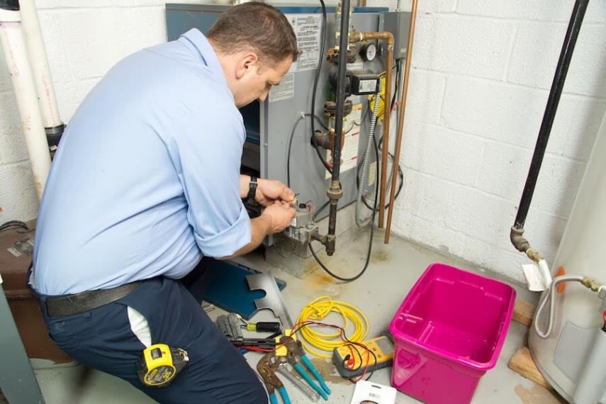 Eagles technician working on a gas heating system in a Chantilly basement